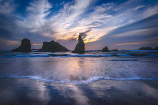 silhouette of rock formation in calm sea, oregon HD wallpaper