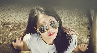shallow focus photography of woman in gray crew-neck shirt wearing gold sunglasses
