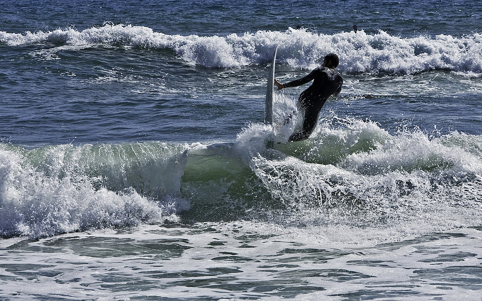 person surfing on sea waves at daytime HD wallpaper