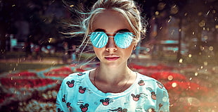 woman wears sunglasses and teal crew-neck shirt