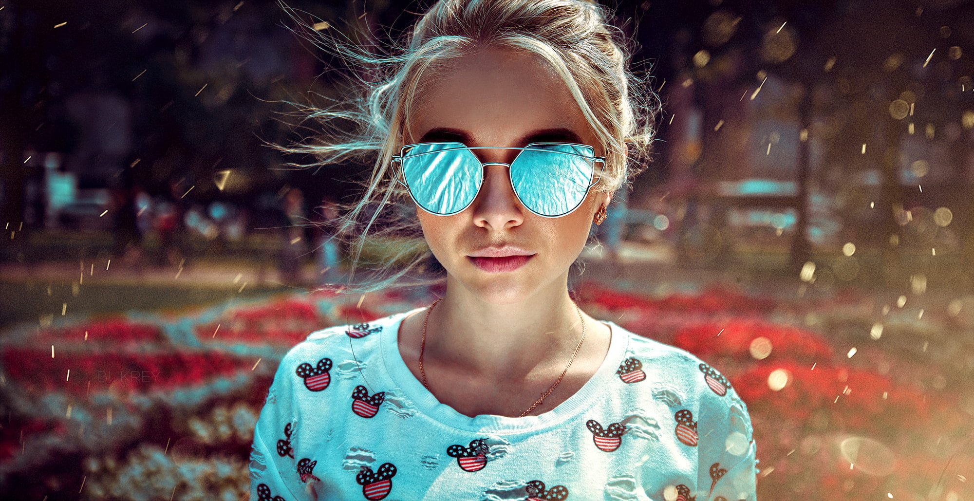 woman wears sunglasses and teal crew-neck shirt