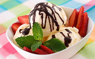 vanilla ice cream with strawberries and chocolate syrup