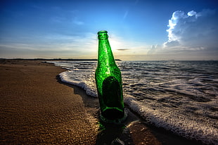 forced photography of green bottle on seashore, sunlight, beach, glass, HDR