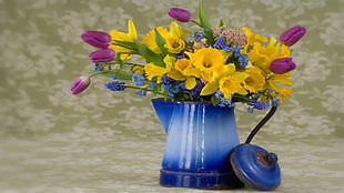 yellow and purple flowers on blue tin planter pitcher with lid