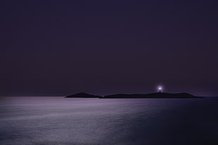 silhouette of lighthouse on the island during nighttime