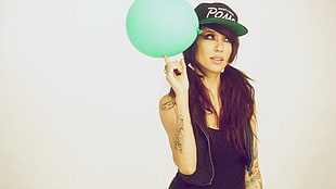 woman in black top holding green balloon