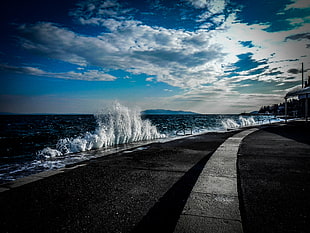 gray concrete road near the ocean water during daytime HD wallpaper