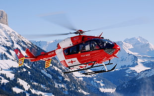 flying red Medic Helicopter under blue sunny sky