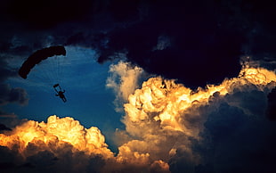 silhouette of paragliding person over clouds during daytime HD wallpaper