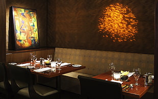 photo of empty brown wooden table with dining ware lot in dark room