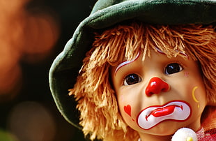 sad clown wearing green hat doll