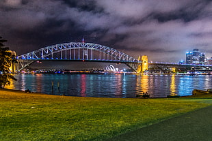 lighted bridge with city view during night time\, sydney harbour bridge