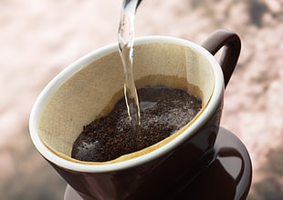 water pours into cup with ground coffee HD wallpaper