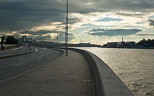 gray concrete road near a body of water