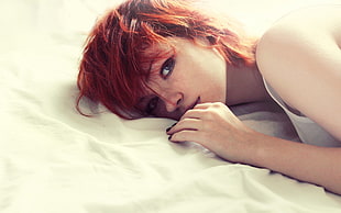red haired woman lying on bed