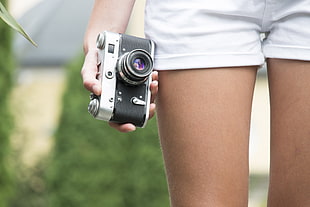 person holding black SLR camera