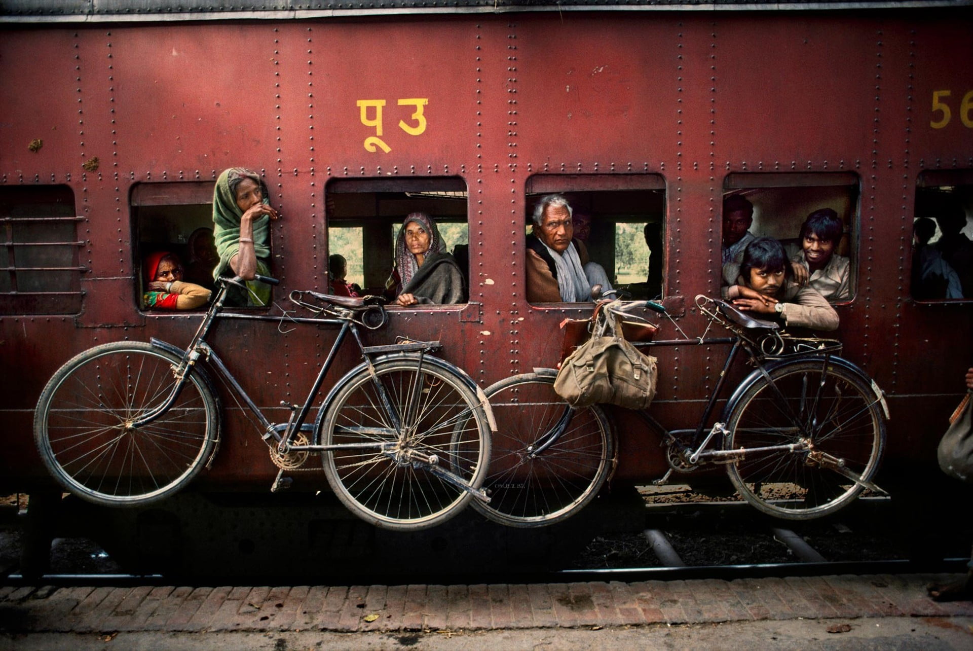 two black and gray commuter bikes, Steve McCurry, India, train station, train