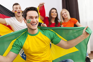man carrying a Brazil flag smiling