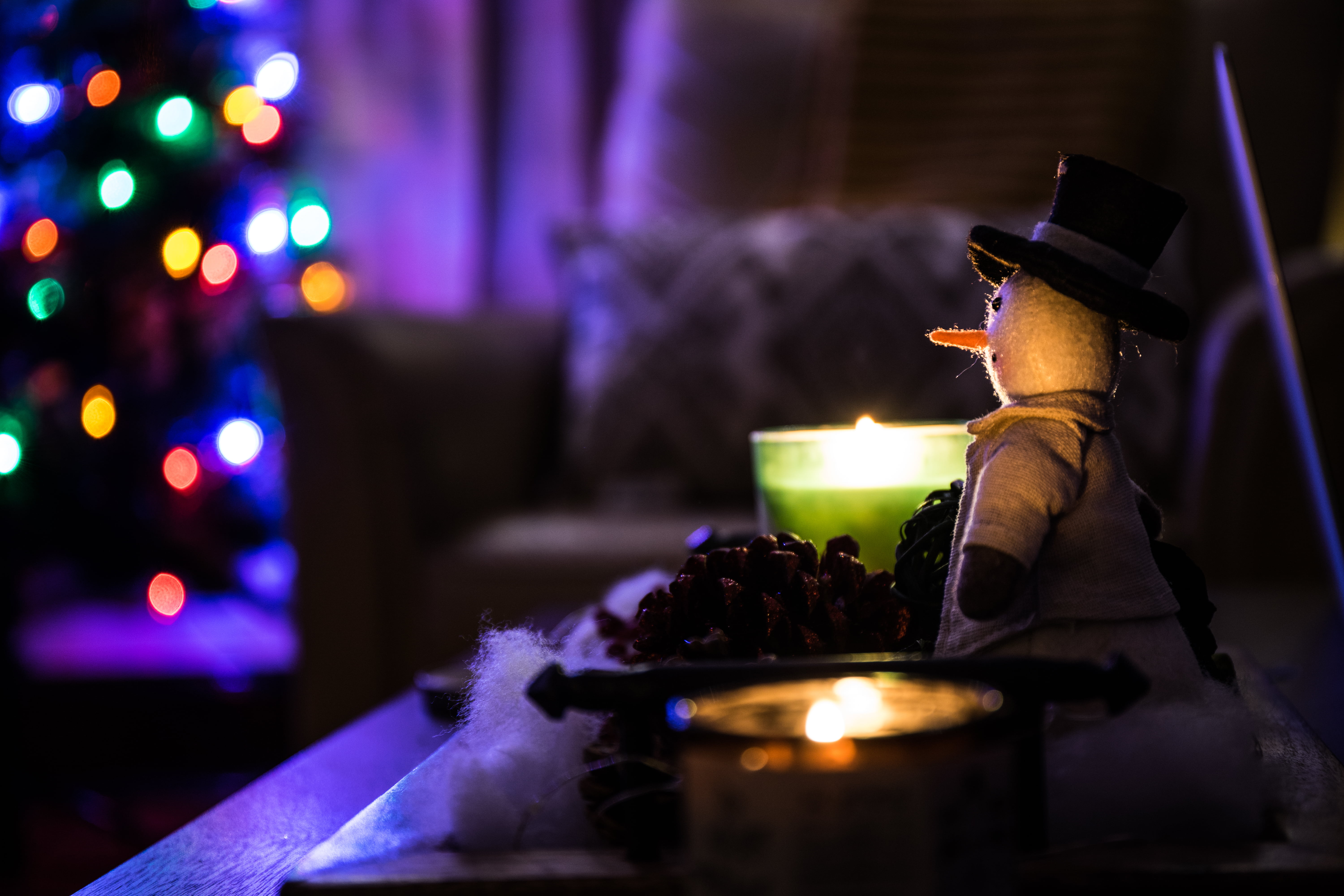 snowman plush toy beside candle