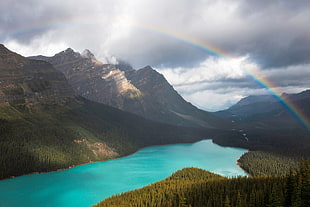 mountains and body of water during cloudy sky, nature, landscape, rainbows, lake