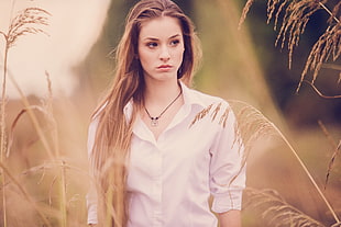 woman wearing white button-up dress shirt standing near gray grasses during daytime HD wallpaper