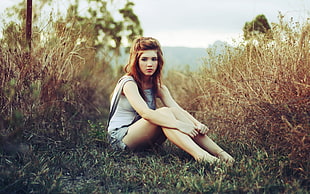 woman in denim jumper sitting on grass