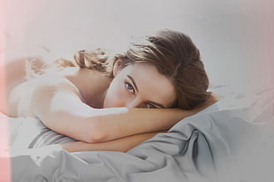 topless woman lying on bed