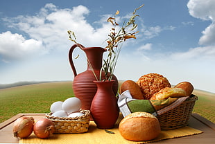 close-up of picnic baskets with pastries and eggs near green grass field under cloudy sky