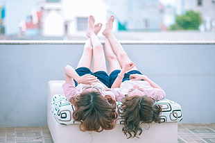 two women on the roof laying on white and gray mattress