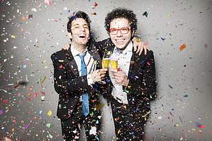 two men in black formal suit jacket surrounded by confetti
