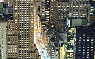 aerial view of concrete city and streets with lights during nighttime