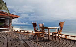 three chairs with table near seashore photography HD wallpaper
