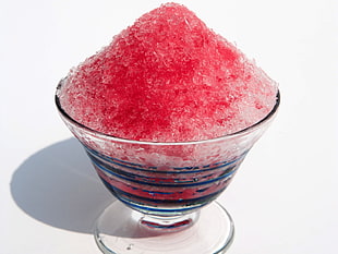 shaved ice with red syrup on glass bowl