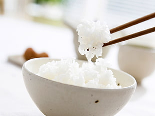 white rice in bowl with chopsticks
