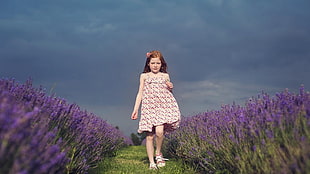 girl standing between purple lavender flower field