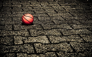 orange basketball on grey concrete brick flooring