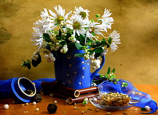 white flowers in blue watering can