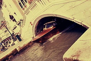 sepia photography of boat under bridge
