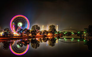 ferris wheel near bridge during night time