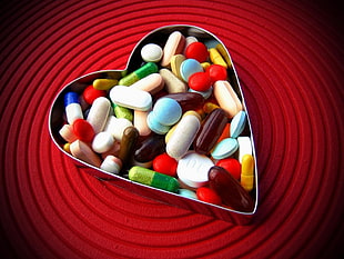assorted color medicine pills in heart shape container HD wallpaper