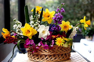 basket of white and yellow Daffodils, yellow and pink Daisies, purple Delphiniums