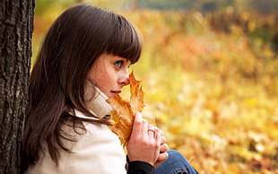 woman holding autumn leaf
