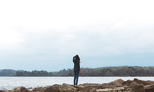 woman in black dress shirt near sea during daytime