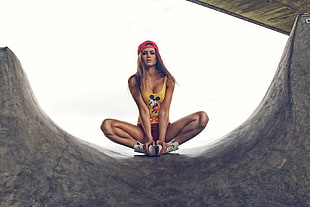 woman wearing yellow tank top holding her sneakers