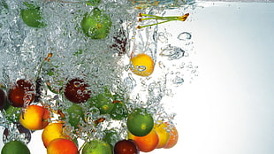 green and orange fruits washed by water