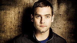 man wearing black jacket and blue shirt