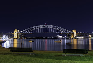 night view of bridge with boats crossing under during nightime, sydney harbour bridge