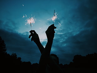 person holding two sparklers