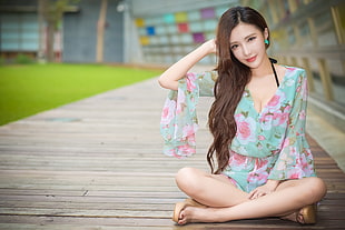 woman wearing teal and pink floral v-neck long-sleeved dress