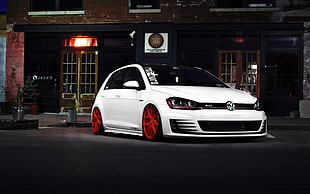 white Volkswagen Golf with red auto rims